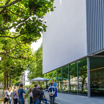 Stadtgäste während einer Führung stehen vor dem Museum