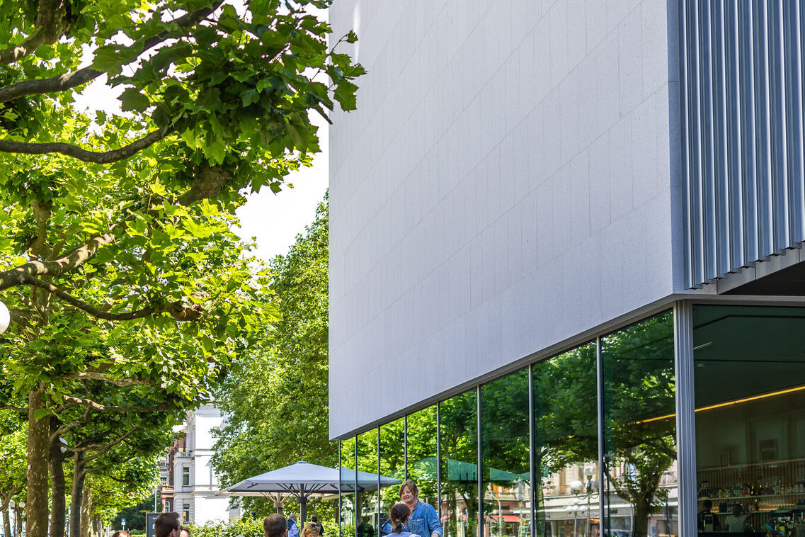 Stadtgäste während einer Führung stehen vor dem Museum