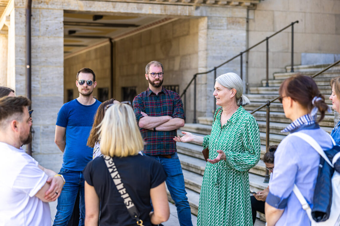 Stadtgäste während einer Führung stehen vor dem Museum