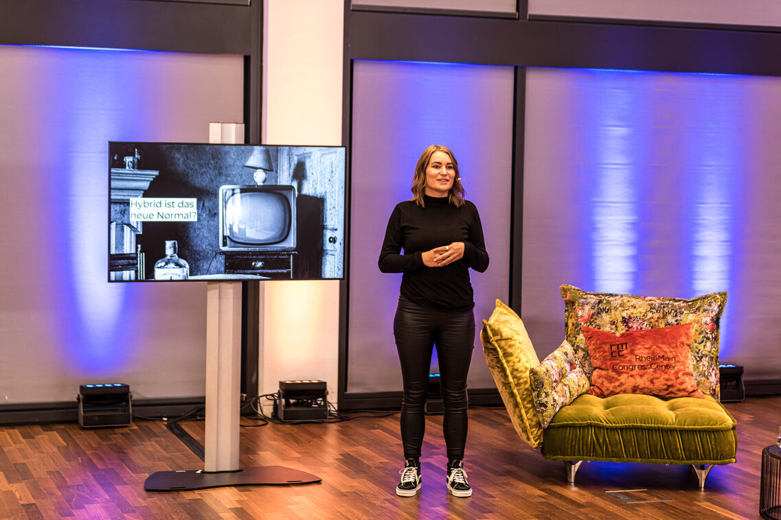 Eine Referentin hält die Rede und zeigt eine Präsentation