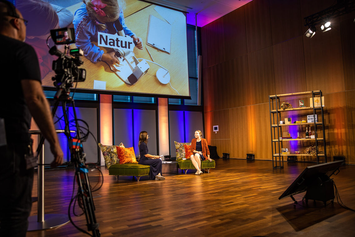 Eine Frau sitzt auf dem Sofa und interviewt eine andere Frau