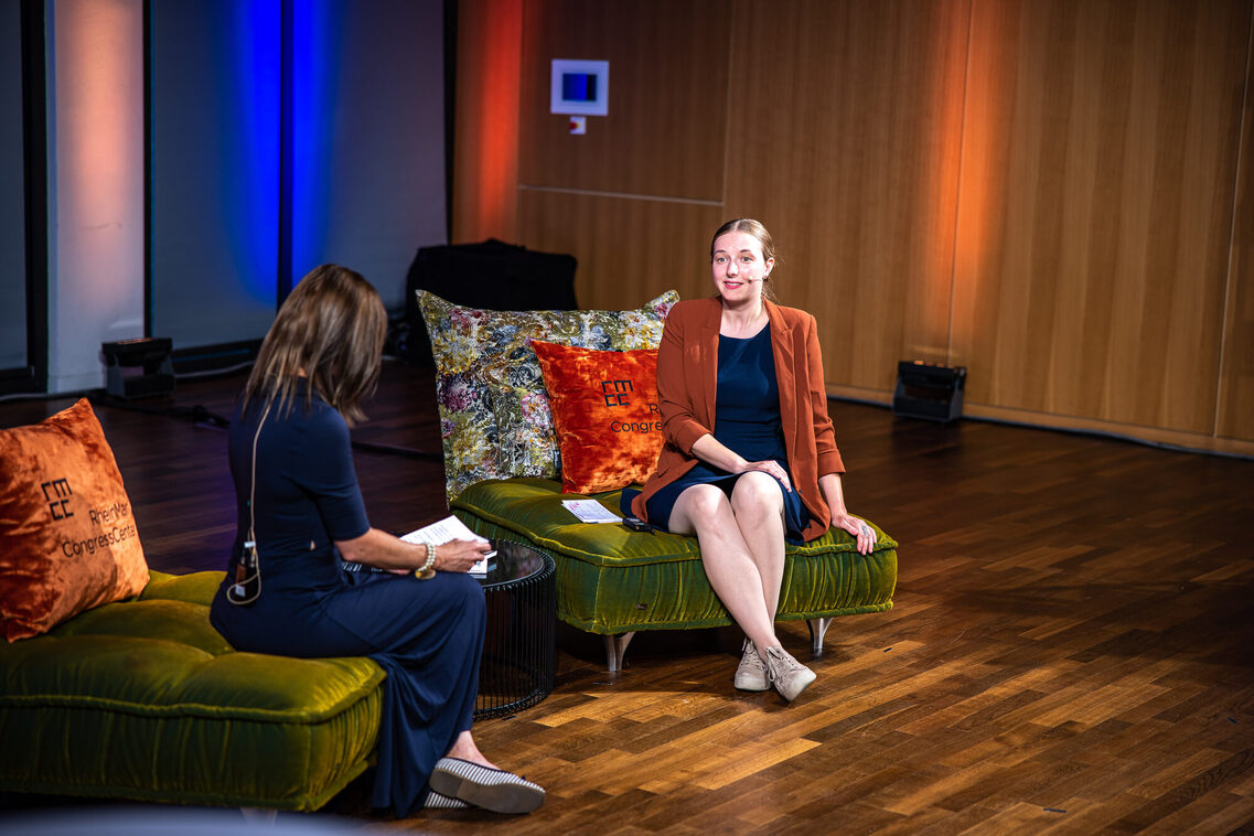 Eine Frau sitzt auf dem Sofa und interviewt eine andere Frau