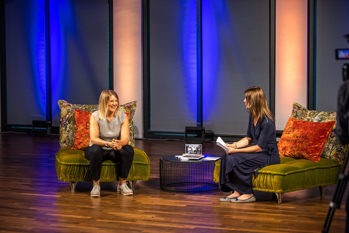 Eine Frau sitzt auf dem Sofa und interviewt eine andere Frau
