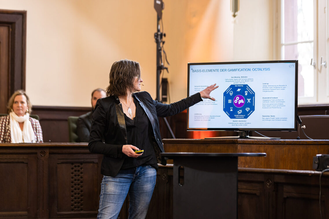 Eine Frau macht eine Präsentation und zeigt auf den Bildschirm