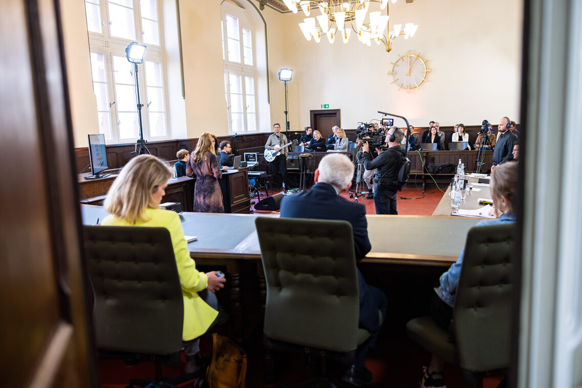 Puplikum sitzt an den Tischen