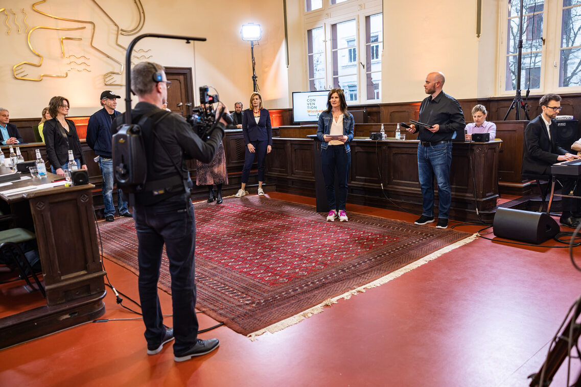 Eine Frau moderiert eine Veranstaltung vor der Kamera