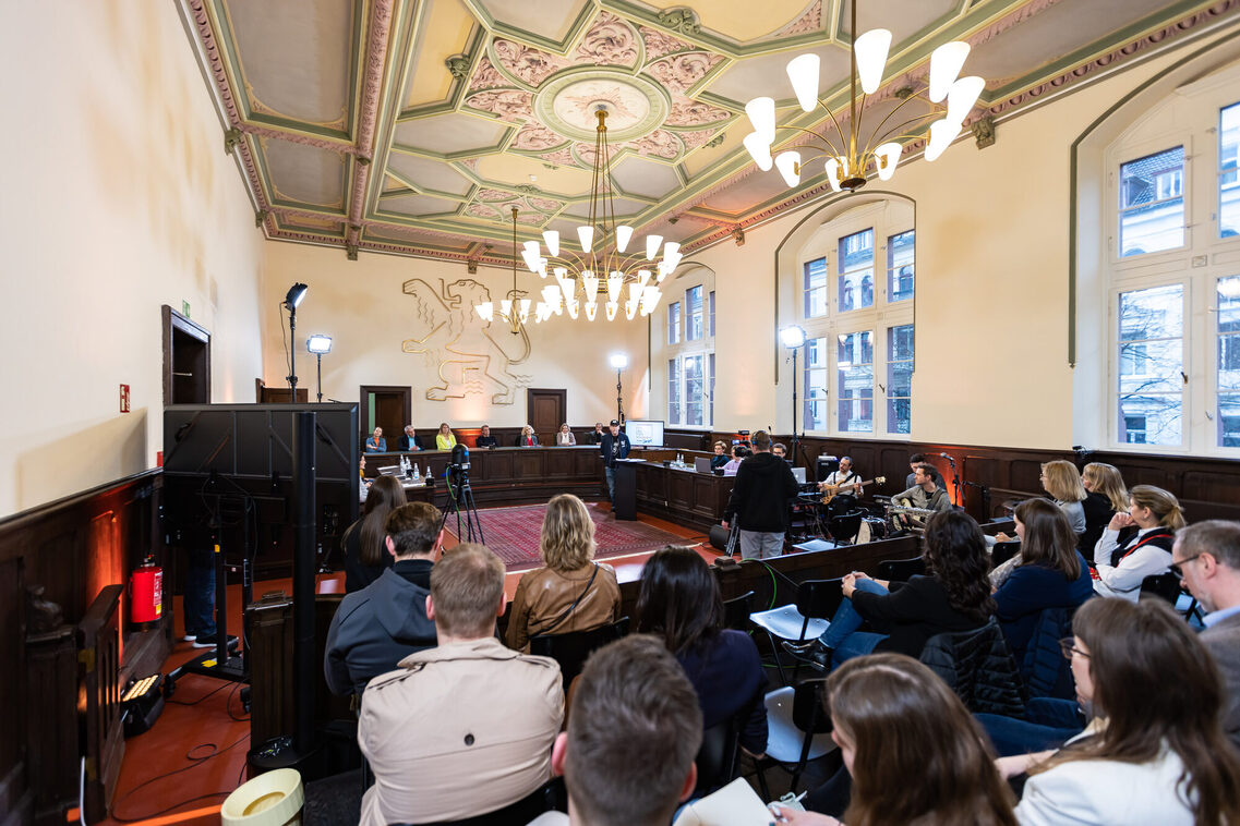 Publiku hört den Vortrag zu