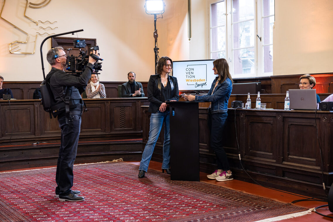 Eine Freu interviewt eien andere Frau und ein Mann filmt