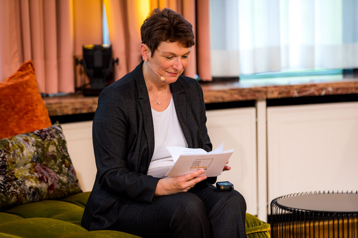 Die Moderatorin in der Lounge-Situation im Streaming-Studio