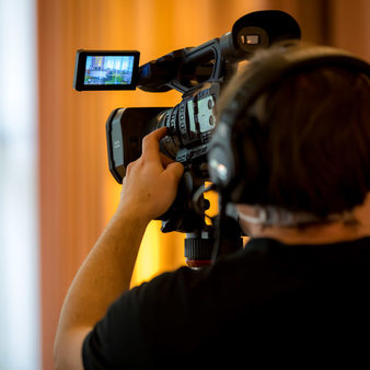 Ein Kameramann mit einer Kamera im Streaming-Studio