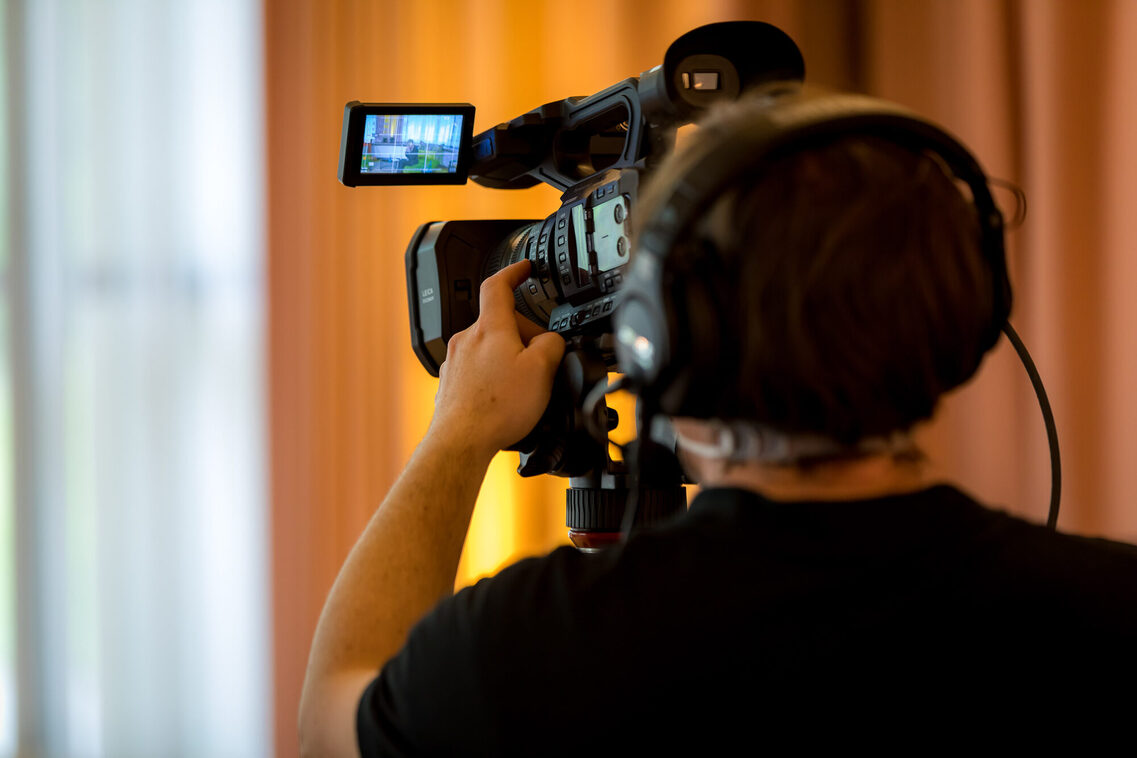 Ein Kameramann mit einer Kamera im Streaming-Studio