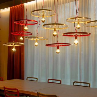 Fünf goldene und rote Lampen hängen über dem Tisch
