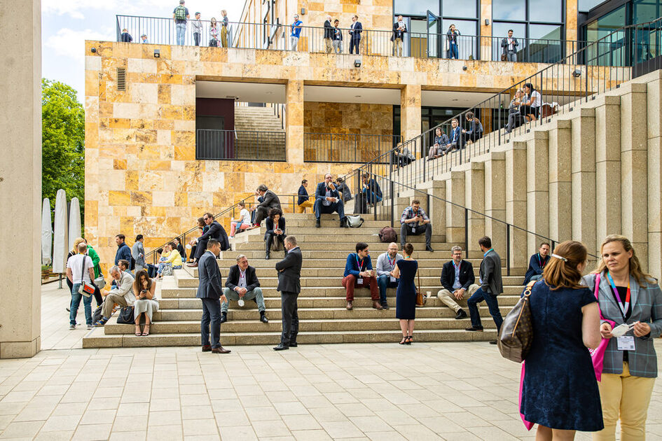 ضيوف المؤتمر يقضون استراحتهم على السلالم أمام مركز رام الله للمؤتمرات