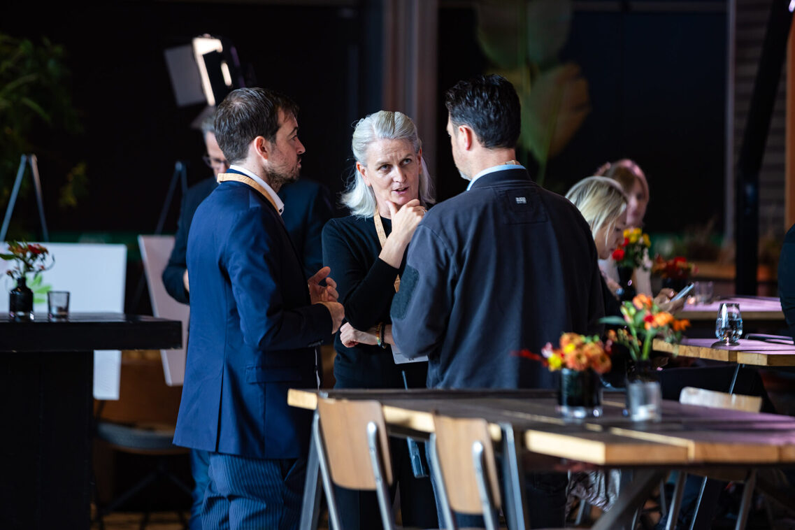 Eine Frau und zwei Männer unterhalten sich in der Messehalle