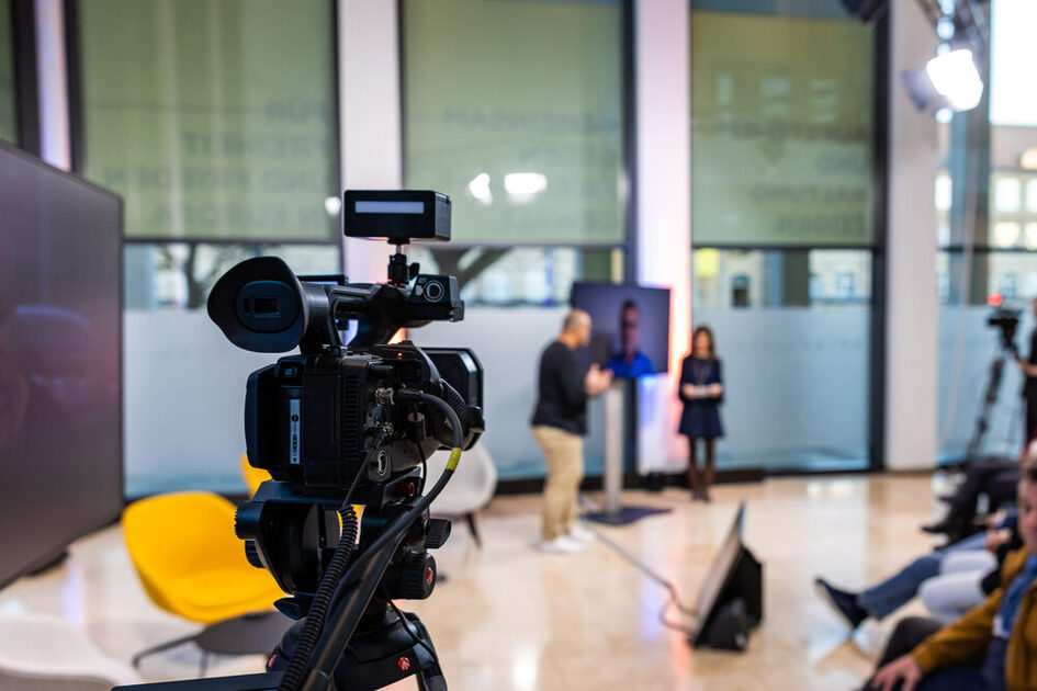 In the foreground you can see a camera at the hybrid event