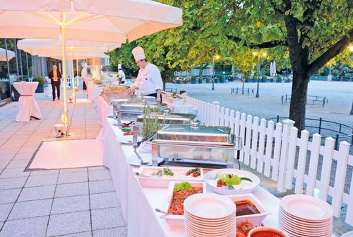 Terrasse Kurhaus - lange Buffetfläche mit Show Cooking Fläche, Sonnenschirmen und Stehtischen auf der Terrasse